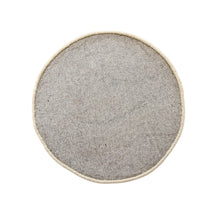 Side angle view of beige smiley face wool kids rug showing its round shape, plush 12-15 mm hand tufted pile and playful cartoon design.