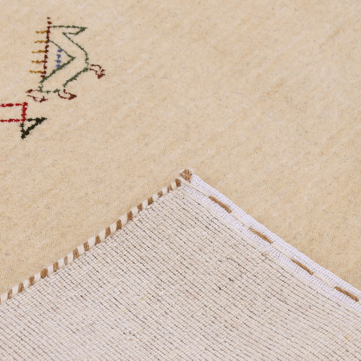 Corner and edge detail of beige Hand Woven Loom Lori wool rug showing handcrafted finish and tribal side motifs