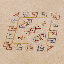 Close-up of beige Hand Woven Loom Lori wool rug showing natural wool texture and delicate tribal motif detailing