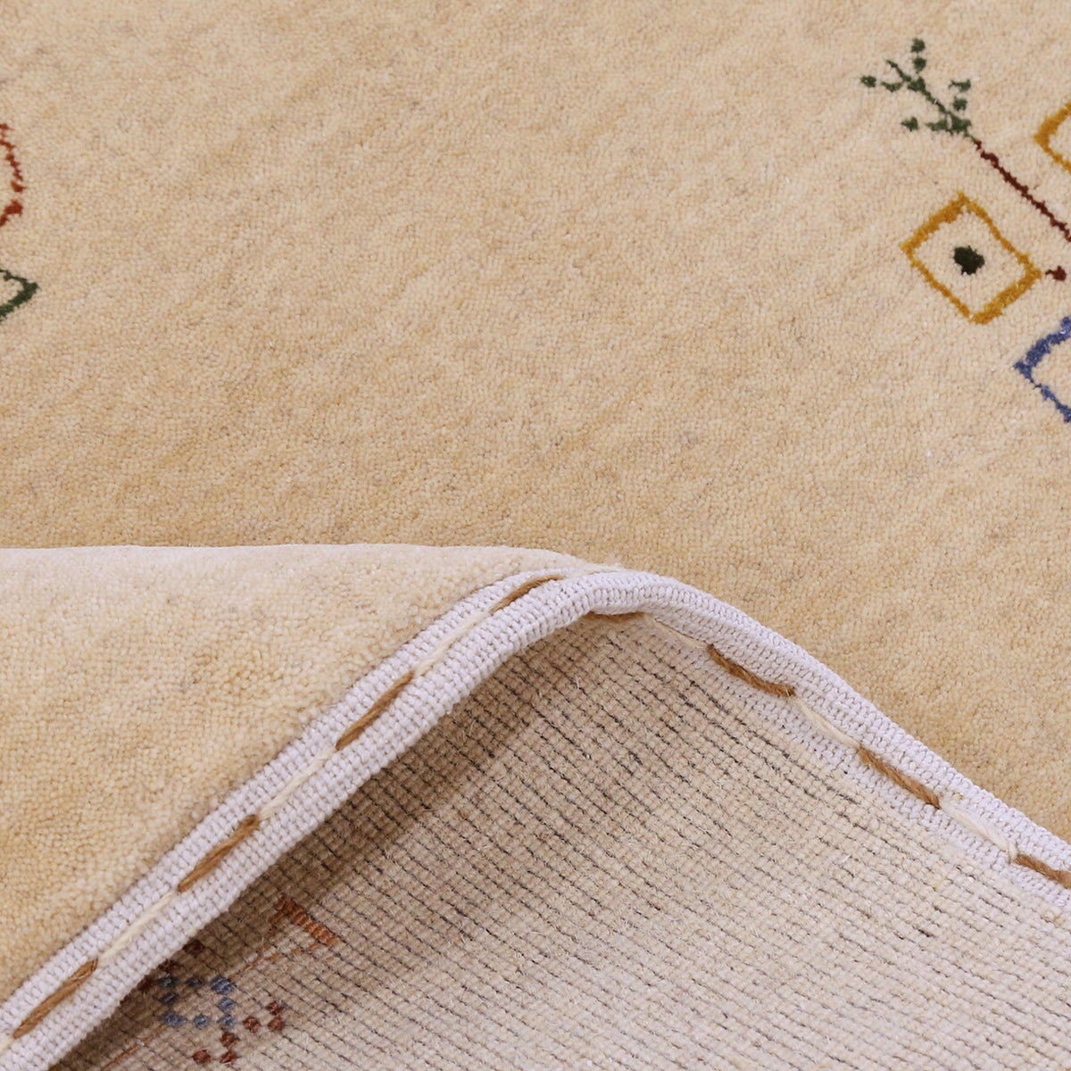 Close-up of beige Hand Woven Loom Lori wool rug showing natural wool texture and delicate tribal motif detailing