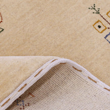 Close-up of beige Hand Woven Loom Lori wool rug showing natural wool texture and delicate tribal motif detailing