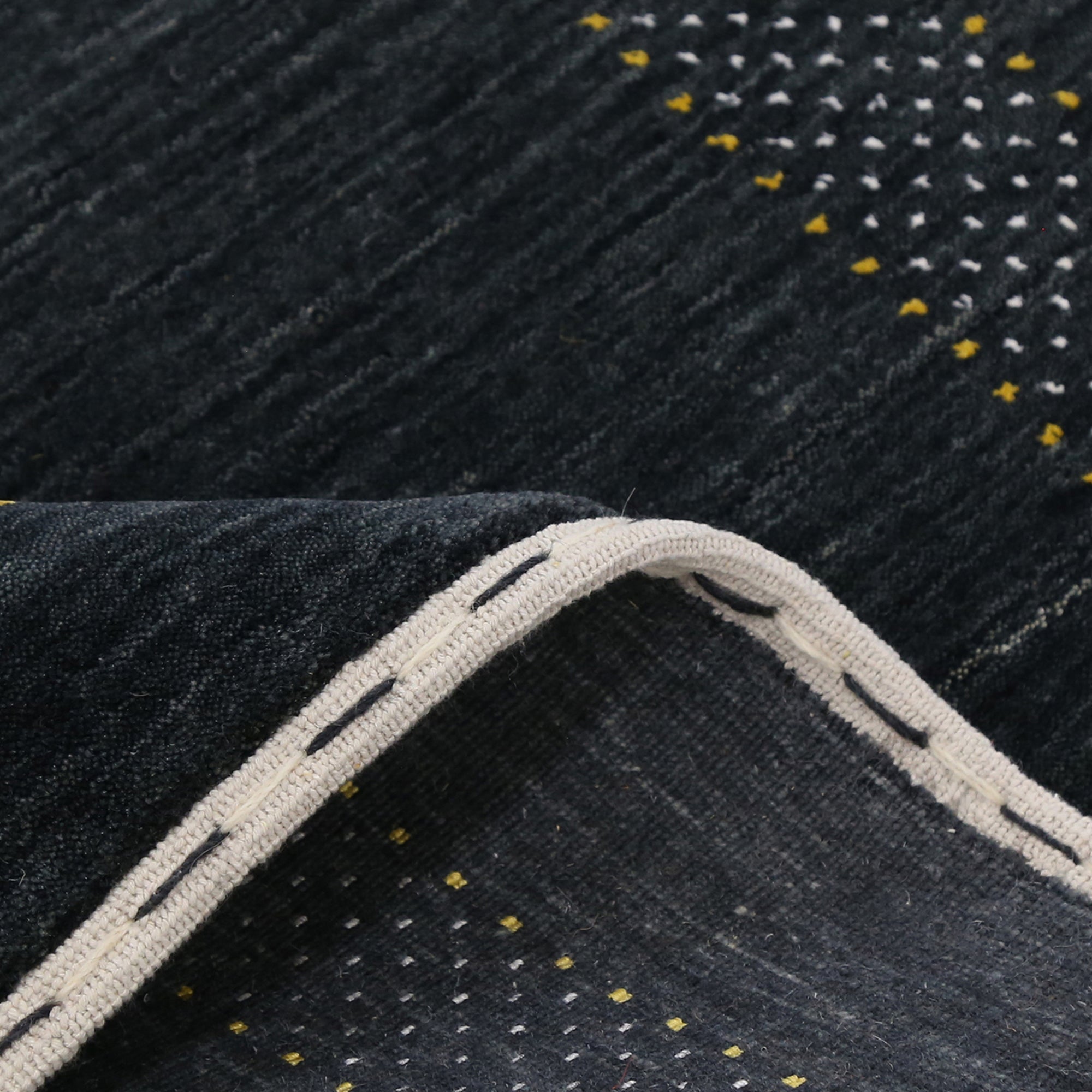 Close-up texture of black Hand Woven Loom Lori wool rug showing natural wool fibres and intricate tribal motif details