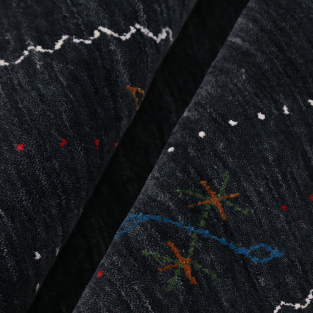 Close-up texture of black Hand Woven Loom Lori wool rug showing natural wool fibres and delicate floral motif detailing