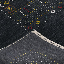 Corner and edge detail of black Hand Woven Loom Lori wool rug showing geometric border and handcrafted finishing