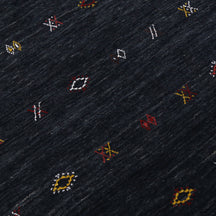 Close-up of charcoal black Hand Woven Loom Lori wool rug showing natural wool texture and multicolour geometric tribal motifs
