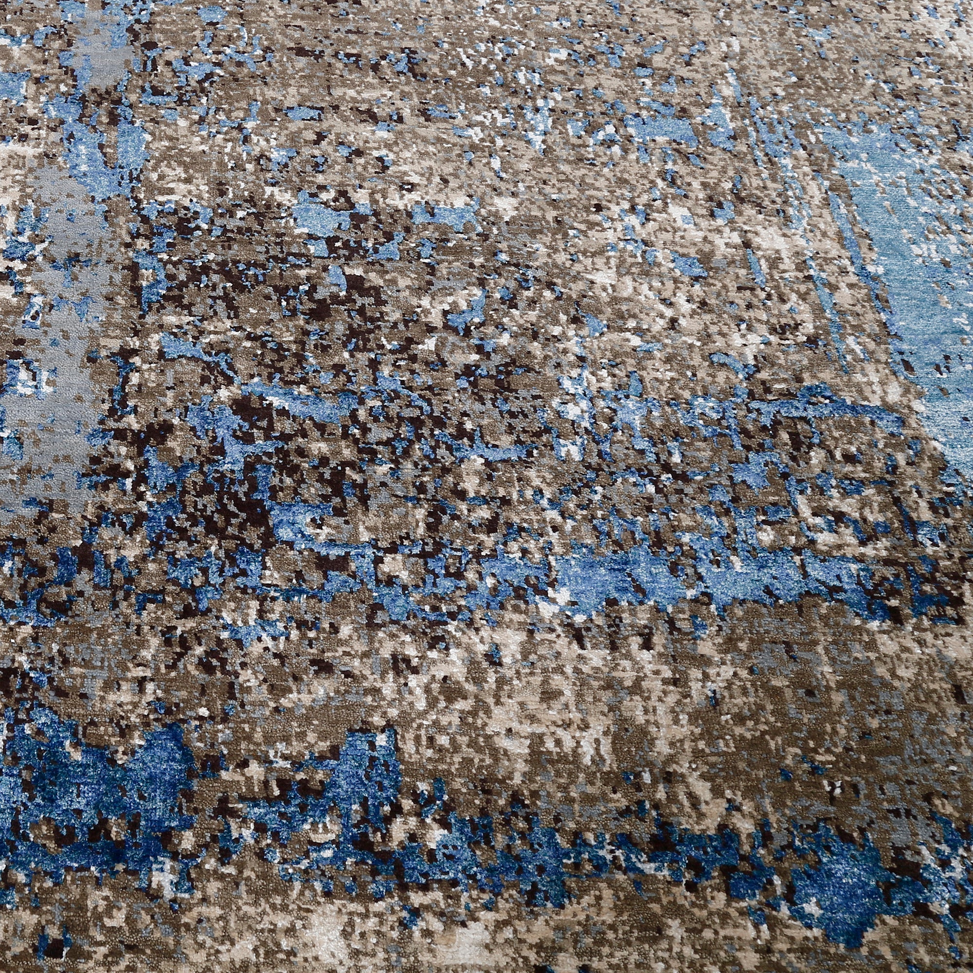 Close-up of the hand knotted wool and viscose texture with taupe slate blue charcoal and beige abstract detailing