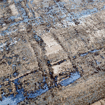 Close-up of the hand knotted wool and viscose texture with taupe slate blue charcoal and beige abstract detailing