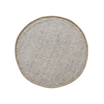 Side angle view of brown happy face wool kids rug showing its round shape, plush 12-15 mm hand tufted pile and playful cartoon design.