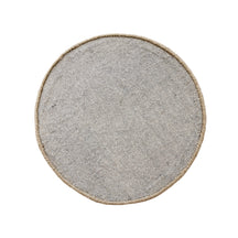 Side angle view of brown smiley face wool kids rug showing its round shape, plush 12-15 mm hand tufted pile and playful cartoon design.