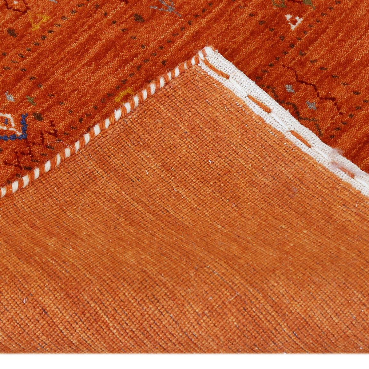 Corner and edge detail of burnt orange Hand Woven Loom Lori wool rug showing natural wool texture and handcrafted finishing