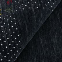 Close-up of charcoal black Hand Woven Loom Lori wool rug showing natural wool texture, botanical symbols and earthy tribal motifs