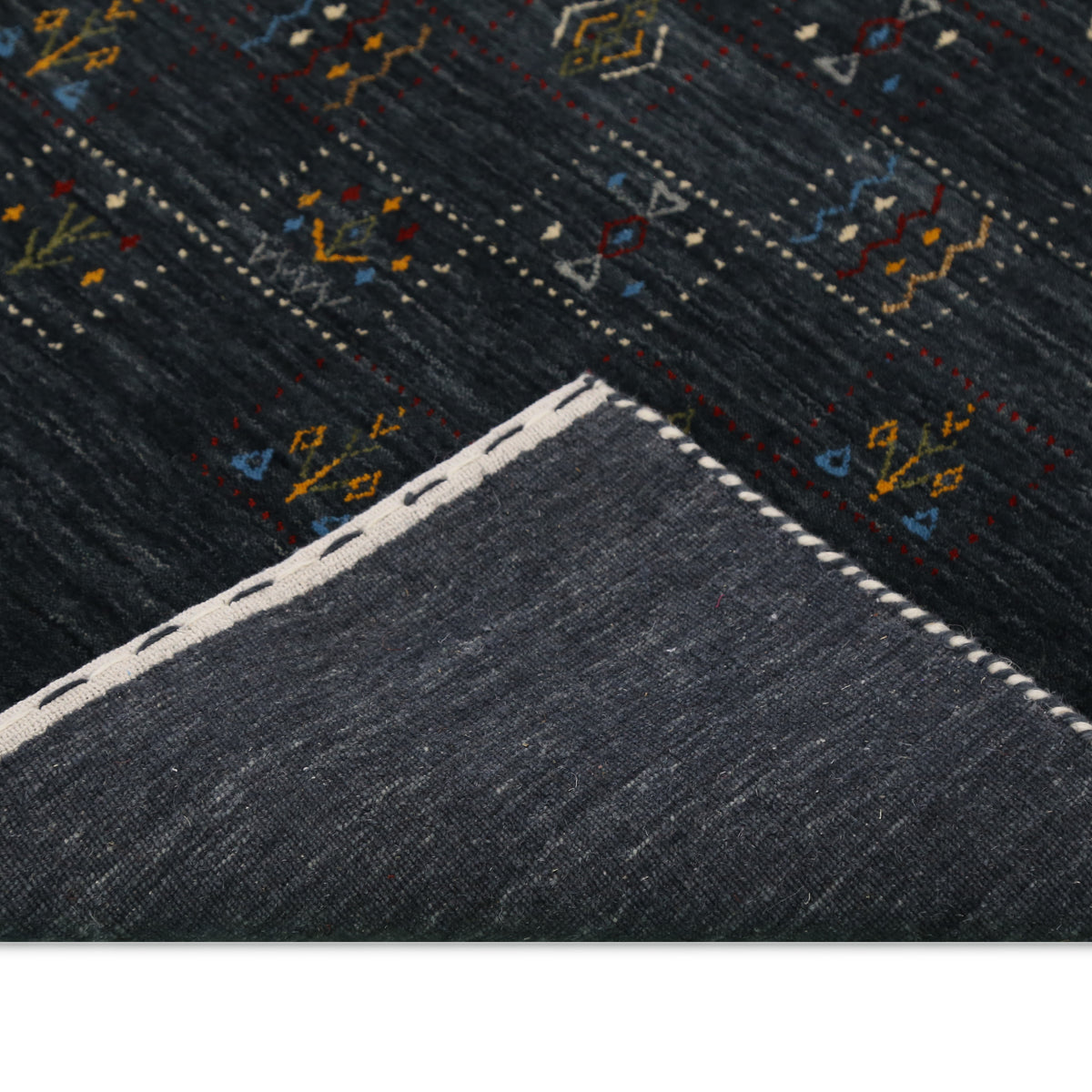 Corner and edge detail of charcoal black Hand Woven Loom Lori wool rug showing handcrafted finishing and wool texture