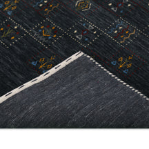 Corner and edge detail of charcoal black Hand Woven Loom Lori wool rug showing handcrafted finishing and wool texture