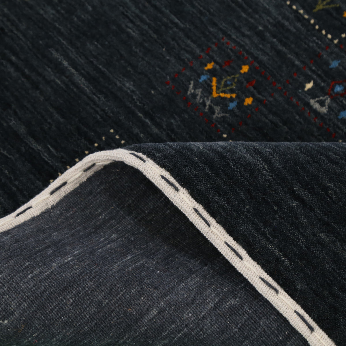 Close-up of charcoal black Hand Woven Loom Lori wool rug showing dotted tribal motif panels and natural wool texture