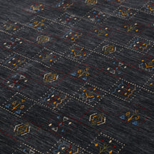 Close-up of charcoal black Hand Woven Loom Lori wool rug showing dotted tribal motif panels and natural wool texture