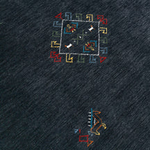 Close-up of charcoal black Hand Woven Loom Lori wool rug showing natural wool texture, diamond detailing and colourful tribal motifs