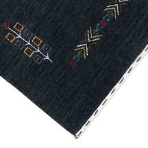 Corner and edge detail of charcoal black Hand Woven Loom Lori wool rug showing handcrafted finish and geometric tribal motifs