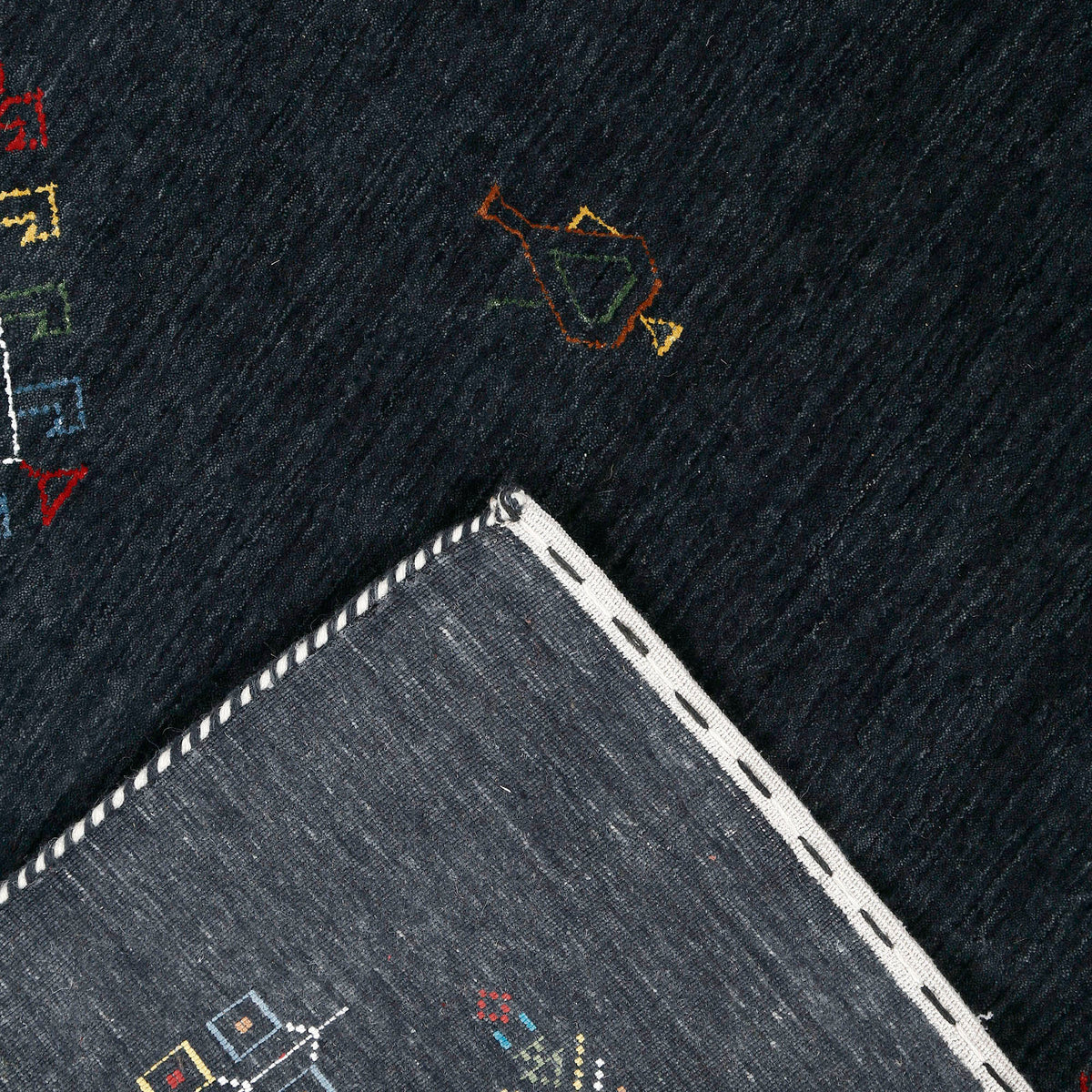 Corner and edge detail of charcoal black Hand Woven Loom Lori wool rug showing handcrafted finish and geometric tribal motifs