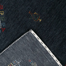 Corner and edge detail of charcoal black Hand Woven Loom Lori wool rug showing handcrafted finish and geometric tribal motifs
