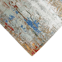 Hand-finished edge and layered distressed detailing of the cloudstone blue abstract hand knotted rug