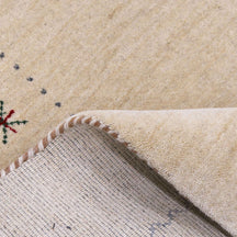Close-up texture of cream Hand Woven Loom Lori wool rug showing natural wool fibres and delicate floral motif detailing
