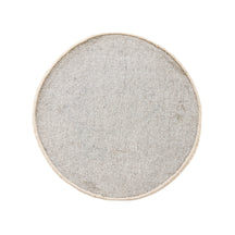 Side angle view of cream happy face wool kids rug showing its round shape, plush 12-15 mm hand tufted pile and playful cartoon design.