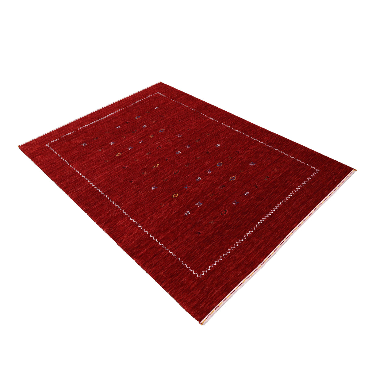 Side perspective of crimson red Hand Woven Loom Lori wool rug highlighting natural wool texture, scattered tribal motifs and ivory zigzag border design