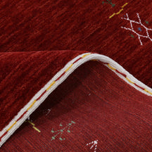 Close-up of deep red Hand Woven Loom Lori wool rug showing natural wool texture and detailed symbolic tribal motifs