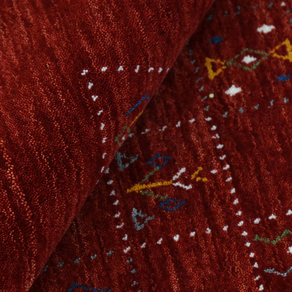 Close-up of crimson red Hand Woven Loom Lori wool rug showing dotted grid panels, diamond motifs and natural wool texture