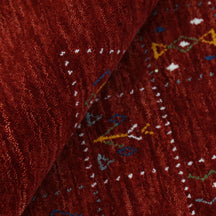Close-up of crimson red Hand Woven Loom Lori wool rug showing dotted grid panels, diamond motifs and natural wool texture