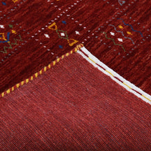 Corner and edge detail of crimson red Hand Woven Loom Lori wool rug showing rich wool texture and handcrafted finishing