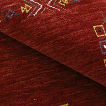Close-up of deep red Hand Woven Loom Lori wool rug showing natural wool texture and geometric tribal detailing