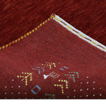 Full view of crimson red Hand Woven Loom Lori wool rug with spacious centre and multicolour dotted tribal folk border