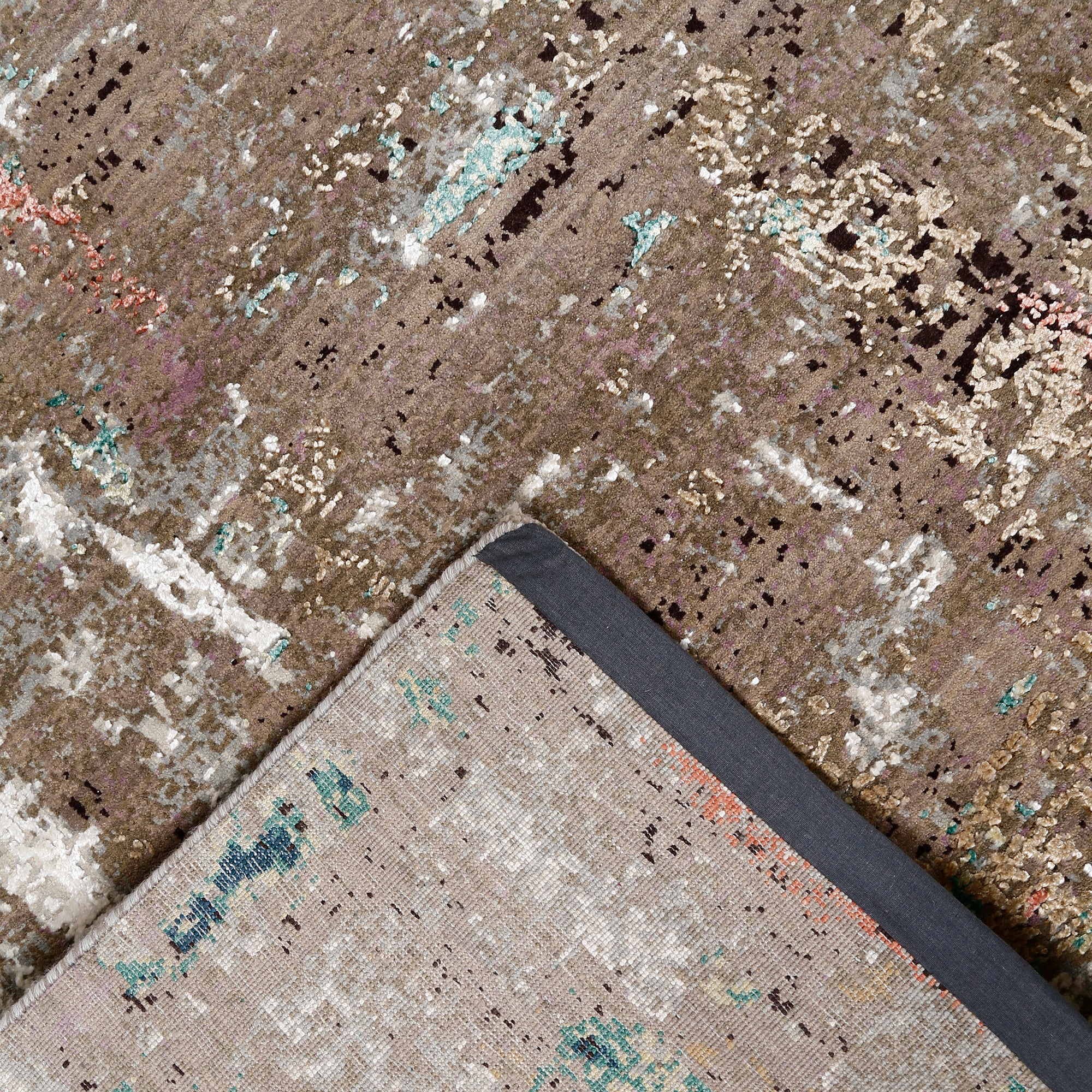 Hand-finished edge and layered distressed surface of the Desert Bloom hand knotted modern rug