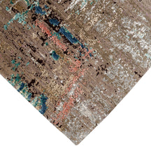 Hand-finished edge and layered distressed surface of the Desert Bloom hand knotted modern rug
