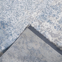 Hand-finished edge and faded ornamental detailing of the frost blue hand knotted rug