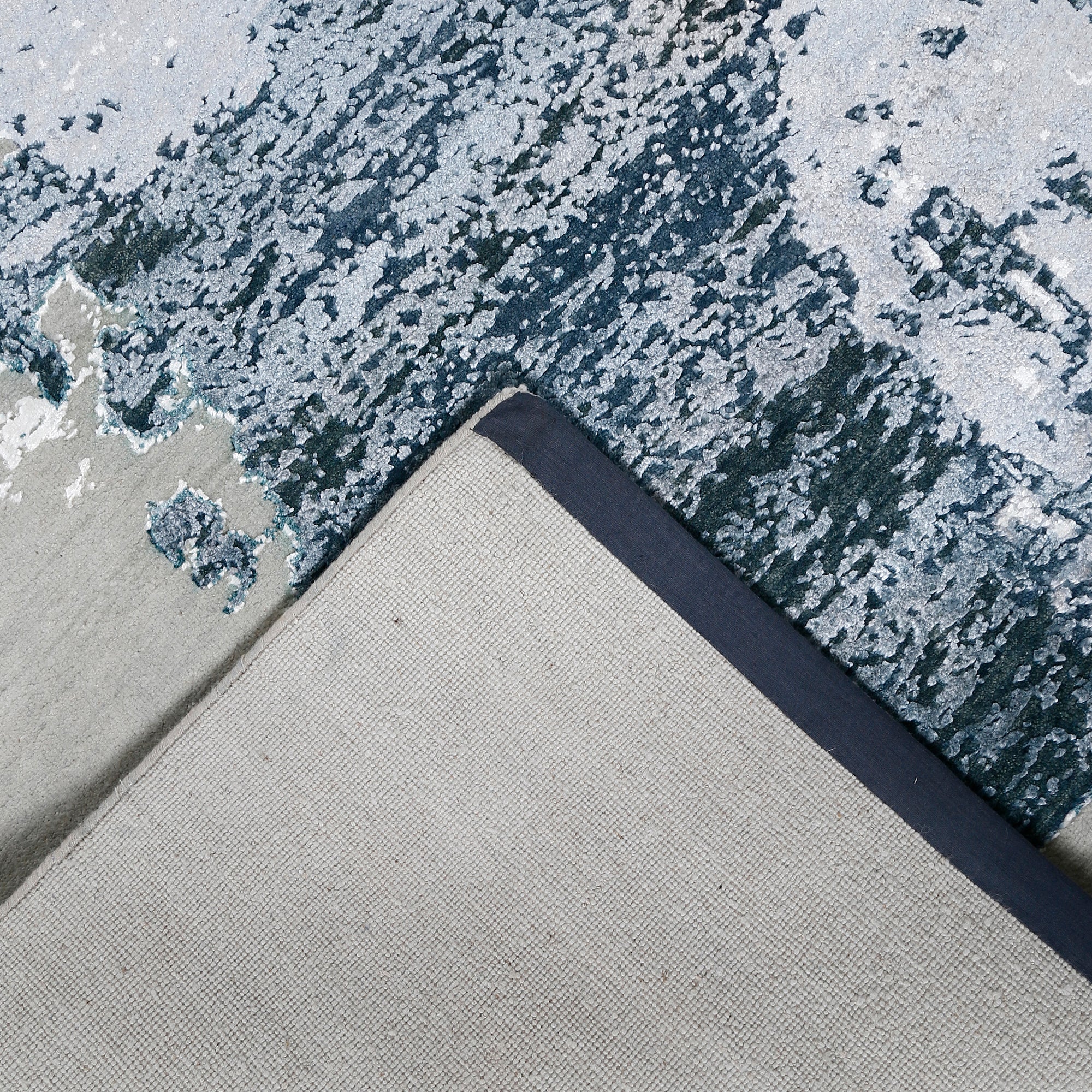 Hand-finished edge and textured abstract surface of the Frosted Echo hand knotted modern rug