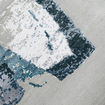 Close-up of the hand knotted wool and viscose texture with light grey ivory and blue abstract detailing