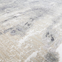 Close-up of the hand knotted wool and viscose texture with silver grey ivory beige and charcoal abstract detailing
