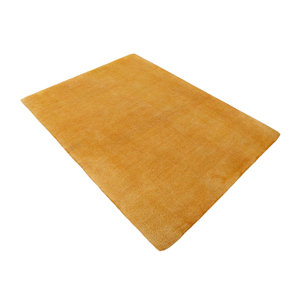 Side angle view of gold hand woven Loom Lori wool rug showing its rectangular shape, plain surface and warm tonal texture.