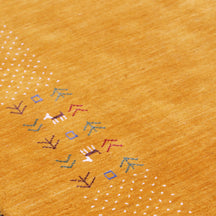 Close-up of golden mustard Hand Woven Loom Lori wool rug showing natural wool texture, botanical symbols and colourful tribal folk motifs