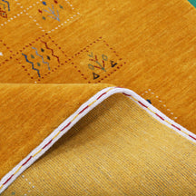 Close-up of golden mustard Hand Woven Loom Lori wool rug showing dotted geometric panels, botanical motifs and natural wool texture
