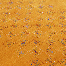 Close-up of golden mustard Hand Woven Loom Lori wool rug showing dotted geometric panels, botanical motifs and natural wool texture