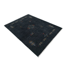 Side perspective of charcoal black Hand Woven Loom Lori wool rug highlighting handcrafted texture and central tribal medallion design