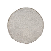 Side angle view of grey smiley face wool kids rug showing its round shape, plush 12-15 mm hand tufted pile and playful cartoon design.