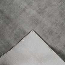 Back detail of grey hand woven Loom Lori wool rug showing its woven underside, finished border and handcrafted construction.