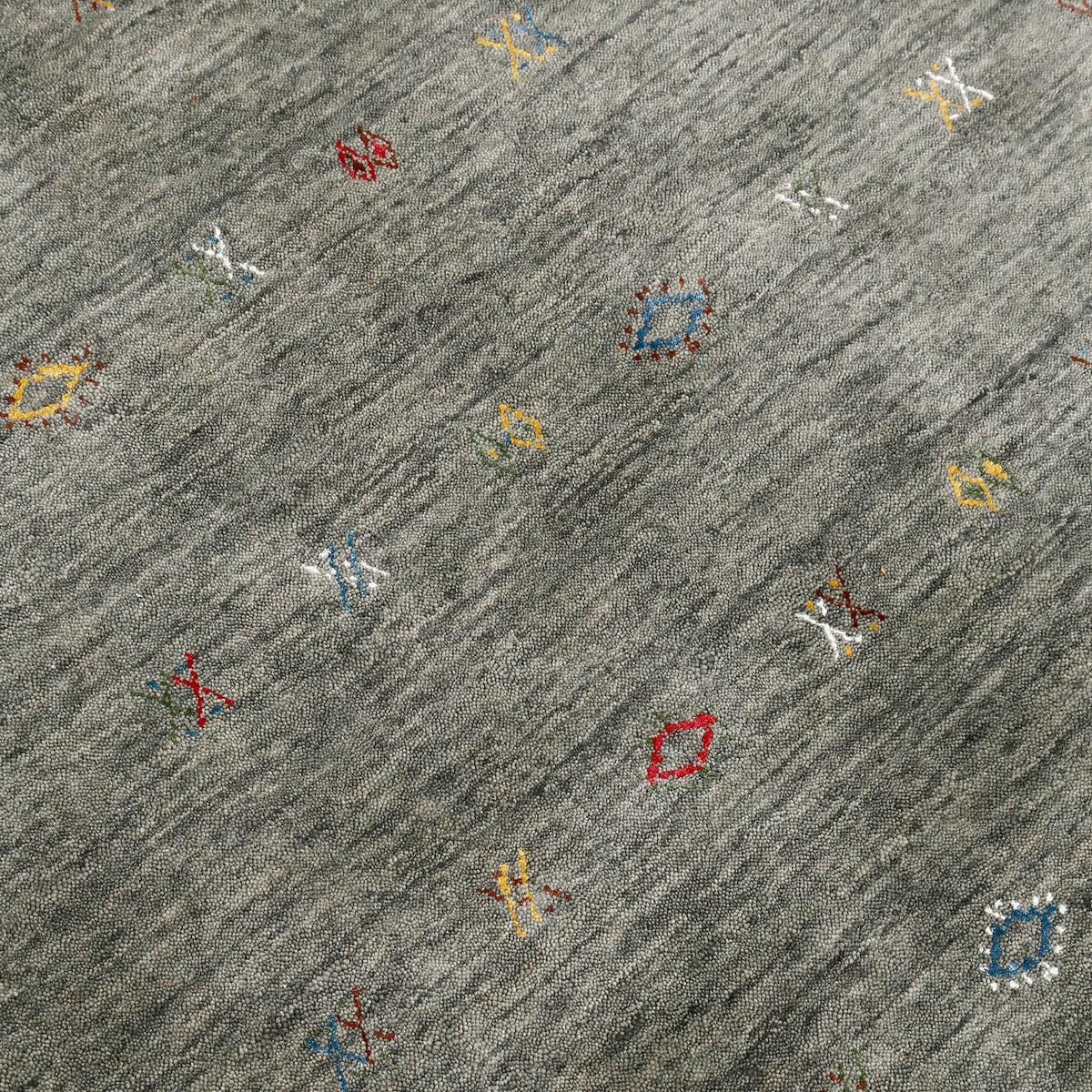 Close-up of slate grey Hand Woven Loom Lori wool rug showing natural wool texture and multicolour tribal geometric motifs