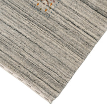 Corner and edge detail of ivory grey Hand Woven Loom Lori wool rug showing natural striations and handcrafted finishing