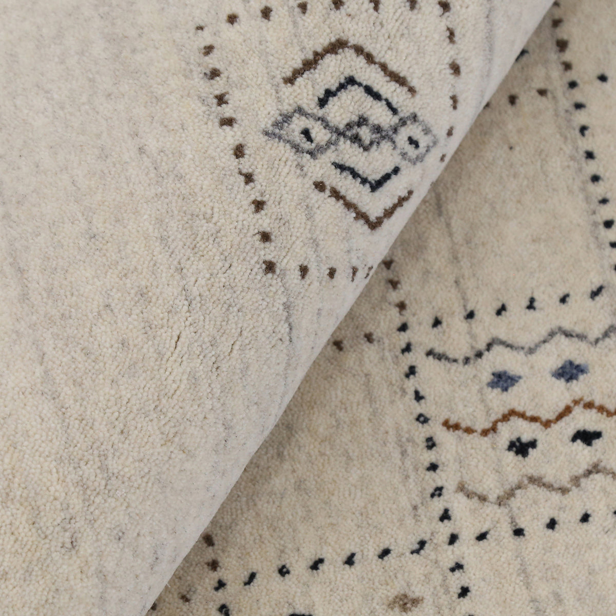 Close-up of ivory beige Hand Woven Loom Lori wool rug showing dotted grid panels, geometric symbols and natural wool texture