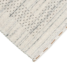 Corner and edge detail of ivory Hand Woven Loom Lori wool rug showing subtle geometric border and handcrafted finishing